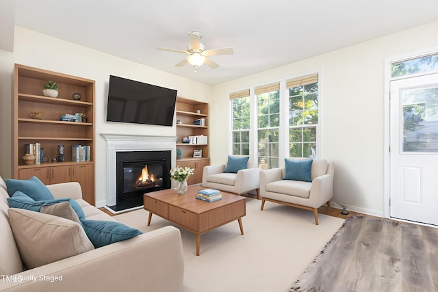 1613 Patterson Grove Rd, Apex, NC 27502 - living room featuring ceiling fan, plenty of natural light, a glass covered fireplace, and wood finished floors
