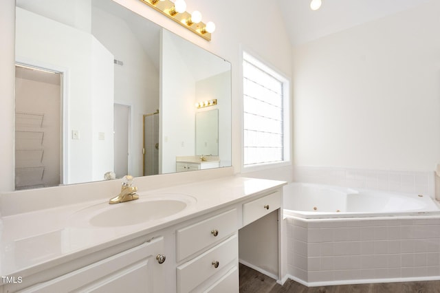 1613 Patterson Grove Rd, Apex, NC 27502 - full bath with vaulted ceiling, a whirlpool tub, vanity, a stall shower, and wood finished floors