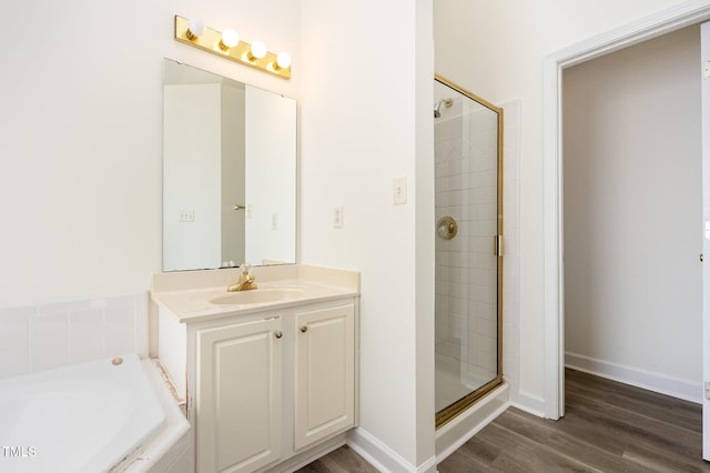 1613 Patterson Grove Rd, Apex, NC 27502 - full bathroom featuring a stall shower, wood finished floors, a garden tub, vanity, and baseboards