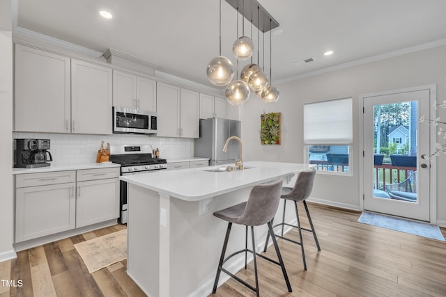 1729 Starlit Sky Ln, Cary, NC 27519 - kitchen featuring stainless steel appliances, ornamental molding, light countertops, backsplash, and an island with sink