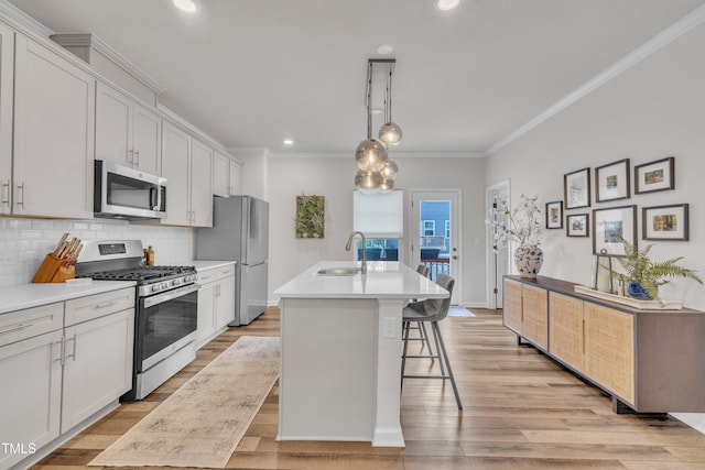 1729 Starlit Sky Ln, Cary, NC 27519 - kitchen featuring stainless steel appliances, ornamental molding, a kitchen island with sink, decorative backsplash, and a breakfast bar area