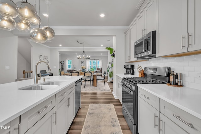 1729 Starlit Sky Ln, Cary, NC 27519 - kitchen with stainless steel appliances, light countertops, dark wood-type flooring, tasteful backsplash, and crown molding