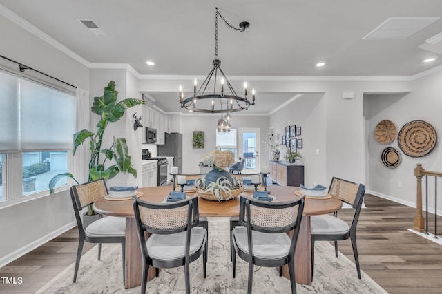 1729 Starlit Sky Ln, Cary, NC 27519 - dining area with wood finished floors, a chandelier, ornamental molding, and recessed lighting