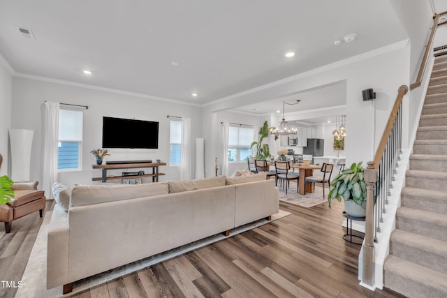 1729 Starlit Sky Ln, Cary, NC 27519 - living area featuring stairway, ornamental molding, wood finished floors, recessed lighting, and a chandelier