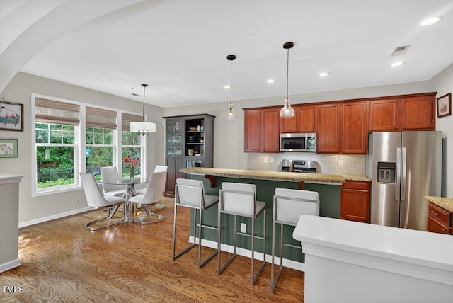 117 Sonoma Way, Chapel Hill, NC 27516 - kitchen featuring stainless steel appliances, wood finished floors, decorative light fixtures, tasteful backsplash, and arched walkways