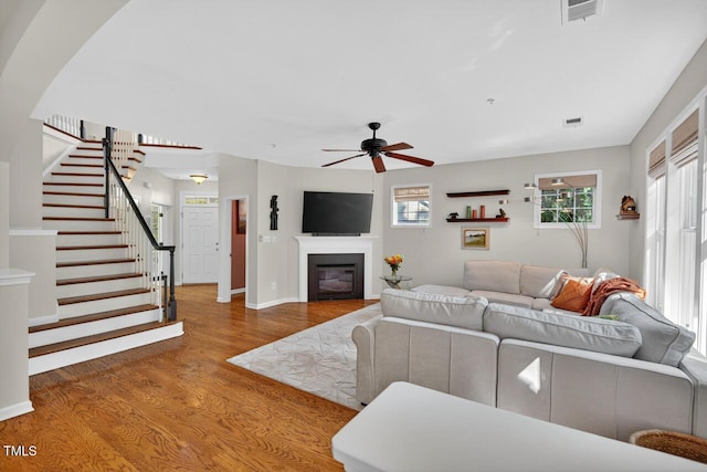 117 Sonoma Way, Chapel Hill, NC 27516 - living area featuring wood finished floors, ceiling fan, stairway, and a glass covered fireplace