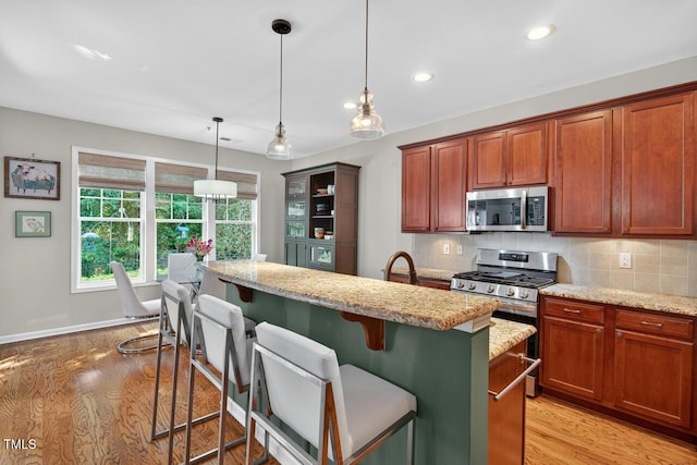 117 Sonoma Way, Chapel Hill, NC 27516 - kitchen with stainless steel appliances, light wood finished floors, light stone counters, tasteful backsplash, and recessed lighting