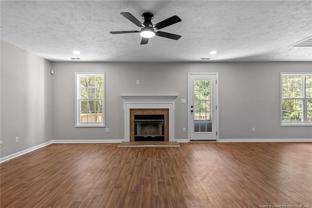 107 Beaumont Ct, Raeford, NC 28376 - unfurnished living room featuring wood finished floors, a fireplace with raised hearth, baseboards, a textured ceiling, and a ceiling fan