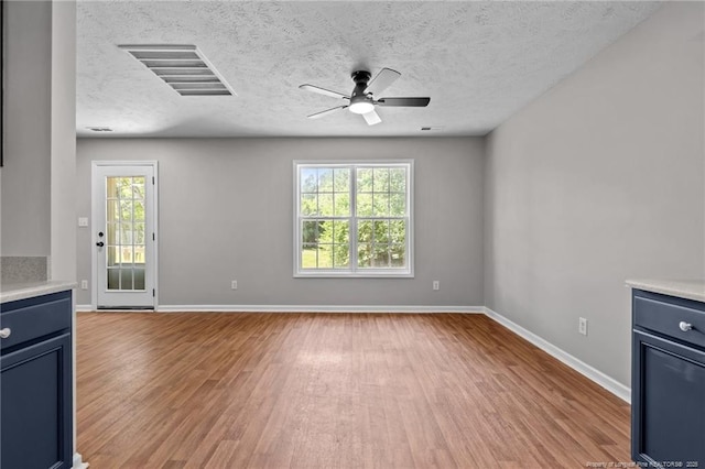 107 Beaumont Ct, Raeford, NC 28376 - unfurnished living room with light wood finished floors, ceiling fan, baseboards, and a textured ceiling