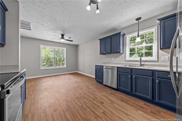 107 Beaumont Ct, Raeford, NC 28376 - kitchen with stainless steel appliances, blue cabinets, a sink, light wood-type flooring, and a textured ceiling