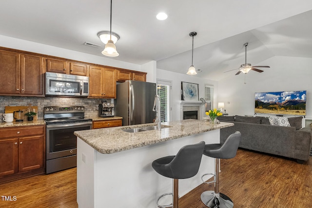 131 Abacos Ct, Clayton, NC 27520 - kitchen with stainless steel appliances, tasteful backsplash, wood finished floors, vaulted ceiling, and a breakfast bar area