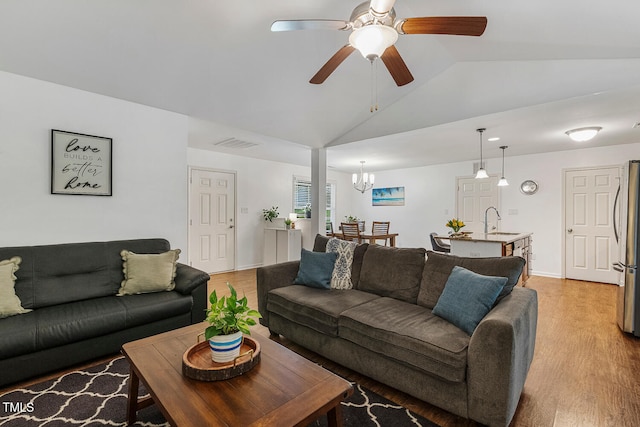 131 Abacos Ct, Clayton, NC 27520 - living room featuring vaulted ceiling, light wood-type flooring, a chandelier, and ceiling fan