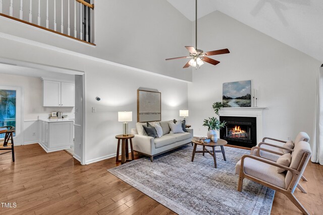 8 Great Oak Ct, Durham, NC 27713 - living room featuring high vaulted ceiling, light wood finished floors, a fireplace with flush hearth, and a ceiling fan