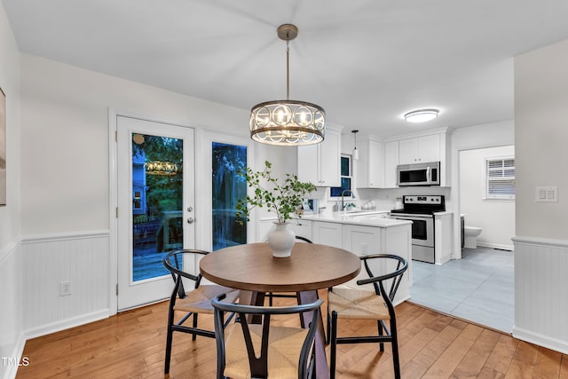 8 Great Oak Ct, Durham, NC 27713 - dining space with wainscoting, light wood finished floors, and a chandelier