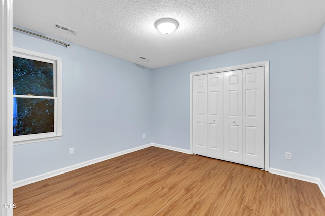 8 Great Oak Ct, Durham, NC 27713 - unfurnished bedroom with wood finished floors, a textured ceiling, and a closet