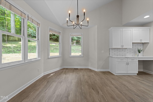6008 Chittim Ct, Raleigh, NC 27616 - unfurnished dining area with lofted ceiling, light wood-style flooring, a chandelier, and baseboards