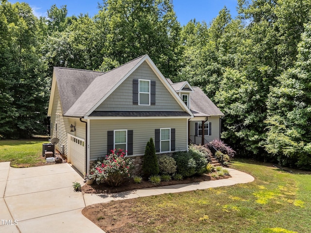 45 Chaucer Ct W, Zebulon, NC 27597 - view of front of house with concrete driveway, a front yard, a shingled roof, central air condition unit, and a garage