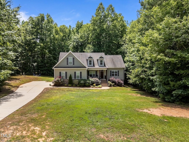 45 Chaucer Ct W, Zebulon, NC 27597 - cape cod home featuring a porch, a front lawn, driveway, and a forest view