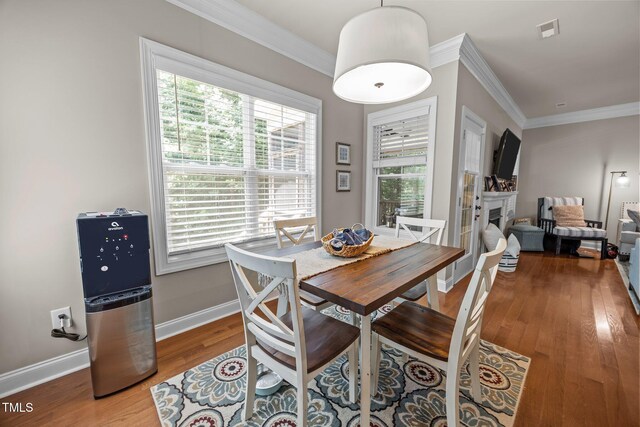 45 Chaucer Ct W, Zebulon, NC 27597 - dining room with crown molding, wood finished floors, a fireplace, plenty of natural light, and baseboards