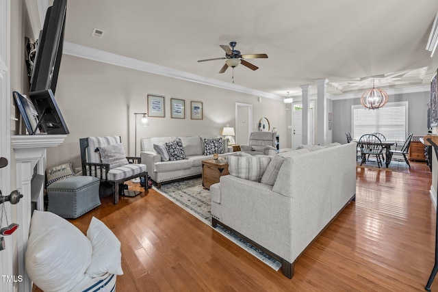 45 Chaucer Ct W, Zebulon, NC 27597 - living area with ornamental molding, a ceiling fan, wood finished floors, a chandelier, and decorative columns