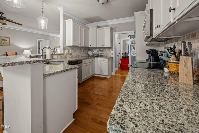 45 Chaucer Ct W, Zebulon, NC 27597 - kitchen with crown molding, stainless steel appliances, ceiling fan, a peninsula, and decorative backsplash
