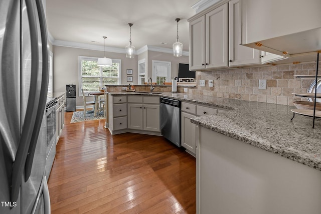45 Chaucer Ct W, Zebulon, NC 27597 - kitchen featuring stainless steel appliances, a sink, a peninsula, tasteful backsplash, and ornamental molding