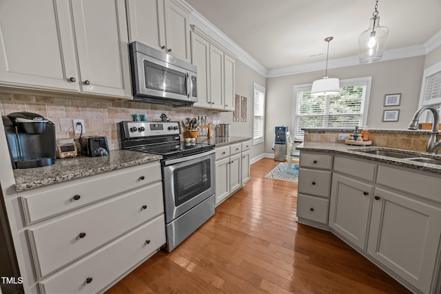 45 Chaucer Ct W, Zebulon, NC 27597 - kitchen featuring appliances with stainless steel finishes, a sink, tasteful backsplash, ornamental molding, and light wood-type flooring