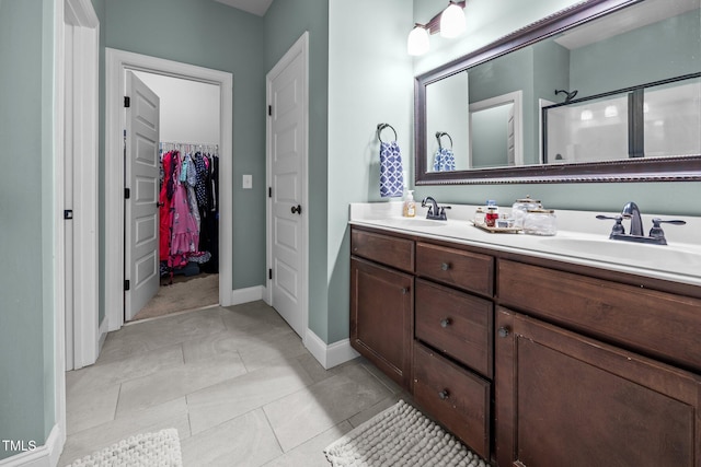 45 Chaucer Ct W, Zebulon, NC 27597 - bathroom with double vanity, a walk in closet, a stall shower, baseboards, and tile patterned flooring