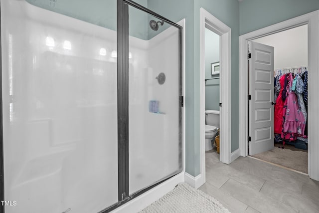 45 Chaucer Ct W, Zebulon, NC 27597 - bathroom featuring a stall shower, a spacious closet, toilet, and baseboards