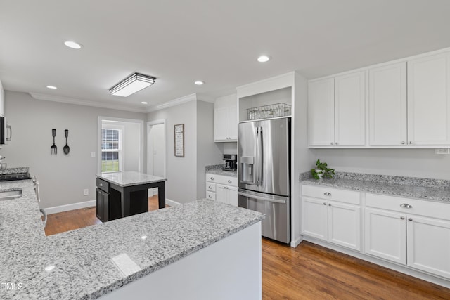 317 Hunters Creek Dr, Goldsboro, NC 27534 - kitchen featuring appliances with stainless steel finishes, white cabinets, wood finished floors, ornamental molding, and light stone counters