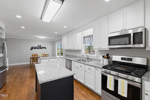 317 Hunters Creek Dr, Goldsboro, NC 27534 - kitchen featuring appliances with stainless steel finishes, a sink, ornamental molding, a kitchen island, and white cabinets