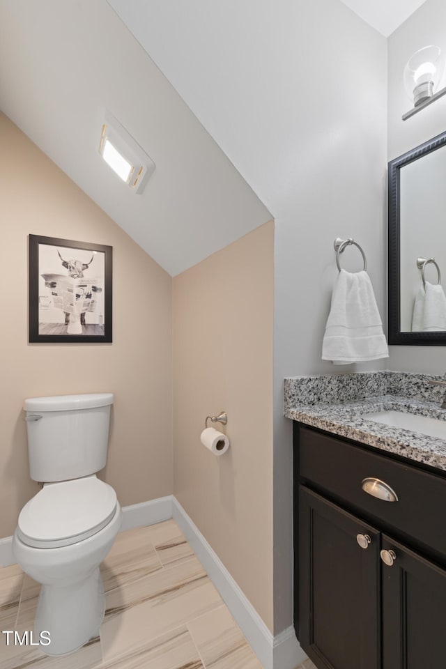 317 Hunters Creek Dr, Goldsboro, NC 27534 - half bathroom with vanity, toilet, lofted ceiling, and baseboards