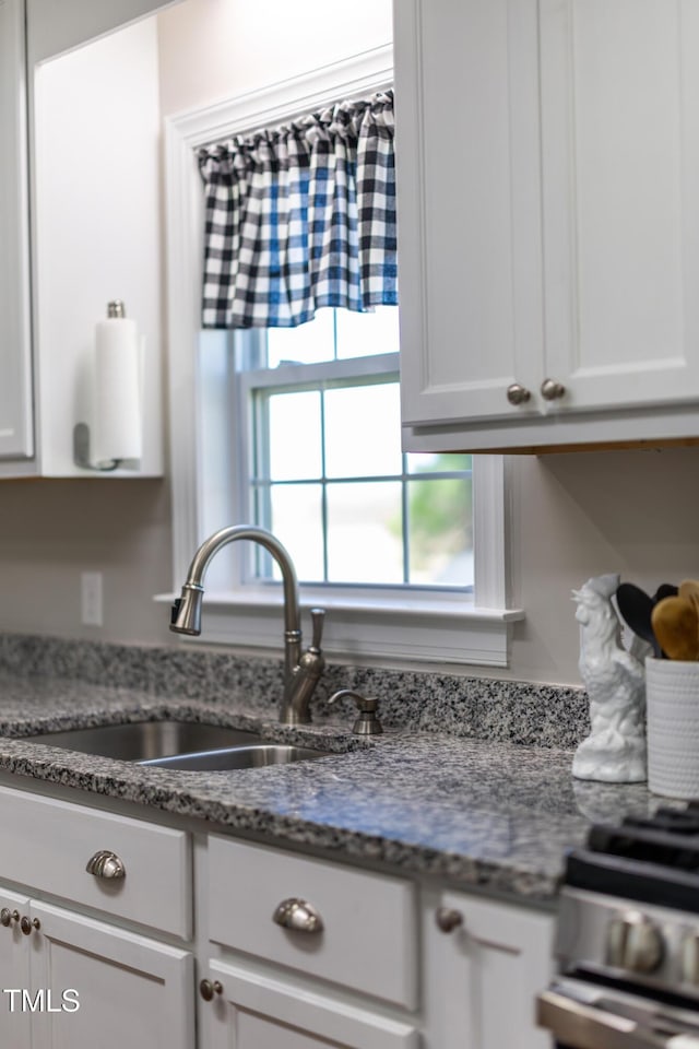 317 Hunters Creek Dr, Goldsboro, NC 27534 - kitchen with a sink, stainless steel range, white cabinetry, and light stone countertops