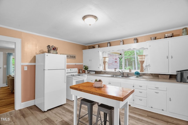 3315 Mebane Oaks Rd, Mebane, NC 27302 - kitchen with white appliances, a sink, white cabinetry, ornamental molding, and light wood-style floors