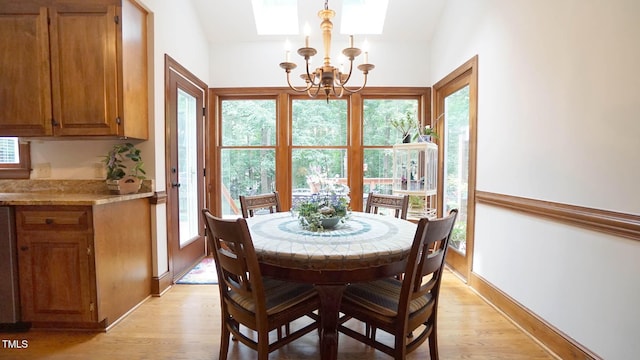 12037 Deer Run, Raleigh, NC 27614 - dining room featuring a chandelier, a skylight, light wood-type flooring, and plenty of natural light