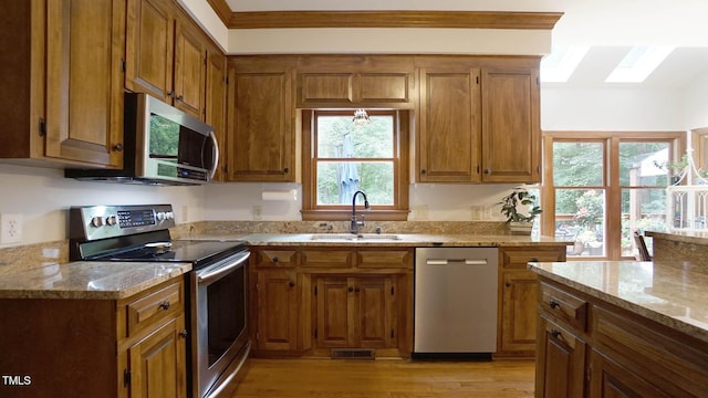 12037 Deer Run, Raleigh, NC 27614 - kitchen featuring appliances with stainless steel finishes, brown cabinetry, and light stone countertops