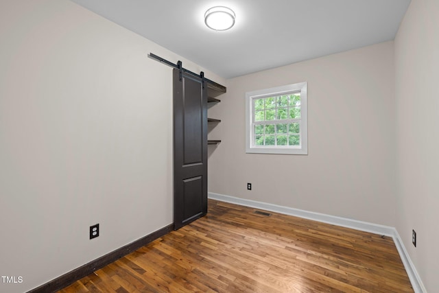 105 Hanna St, Carrboro, NC 27510 - unfurnished bedroom with wood finished floors and a barn door