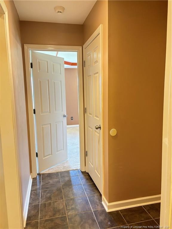 5733 Azure Dr, Hope Mills, NC 28348 - hallway with baseboards and dark tile patterned floors