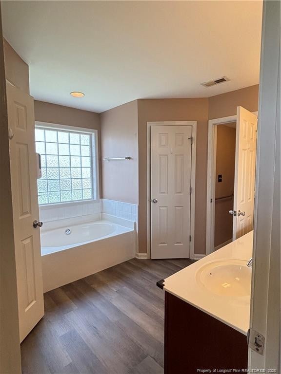 5733 Azure Dr, Hope Mills, NC 28348 - full bathroom with a garden tub, vanity, and wood finished floors