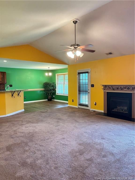 5733 Azure Dr, Hope Mills, NC 28348 - unfurnished living room featuring vaulted ceiling, baseboards, a fireplace, ceiling fan, and carpet floors