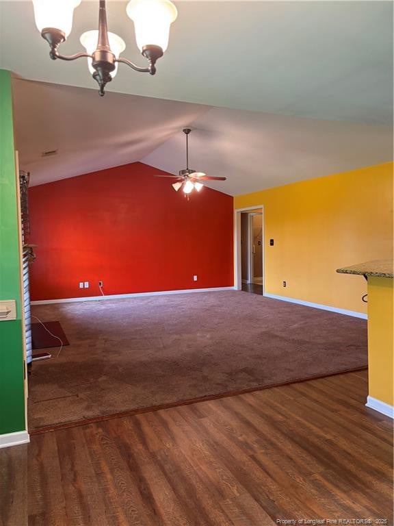 5733 Azure Dr, Hope Mills, NC 28348 - unfurnished living room with baseboards, a chandelier, lofted ceiling, dark wood-type flooring, and a ceiling fan