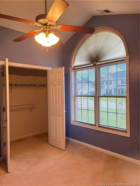 5733 Azure Dr, Hope Mills, NC 28348 - unfurnished bedroom featuring light carpet, a closet, lofted ceiling, baseboards, and ceiling fan