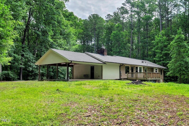 224 Oakcrest Dr, Wake Forest, NC 27587 - view of front facade featuring a chimney, a front lawn, a wooden deck, and an attached carport