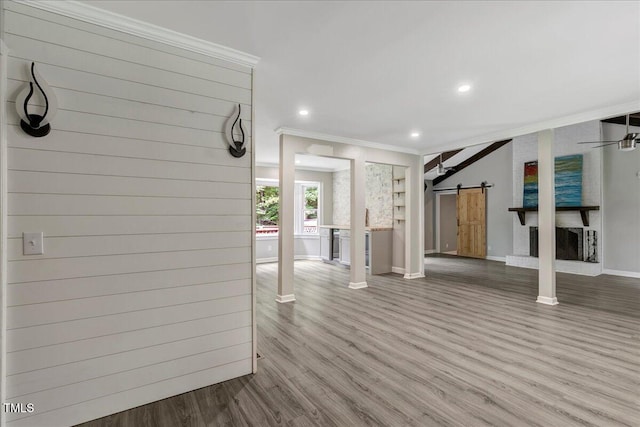 224 Oakcrest Dr, Wake Forest, NC 27587 - unfurnished living room featuring a barn door, ornamental molding, wood finished floors, baseboards, and recessed lighting