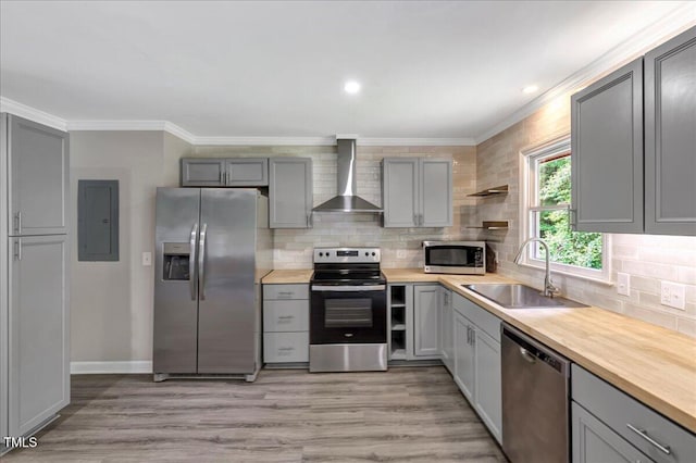 224 Oakcrest Dr, Wake Forest, NC 27587 - kitchen featuring stainless steel appliances, wall chimney range hood, a sink, gray cabinetry, and crown molding