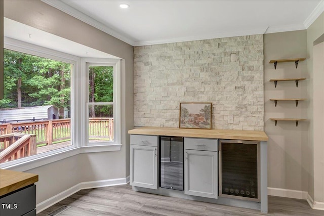 224 Oakcrest Dr, Wake Forest, NC 27587 - indoor dry bar featuring beverage cooler, crown molding, baseboards, and light wood-type flooring
