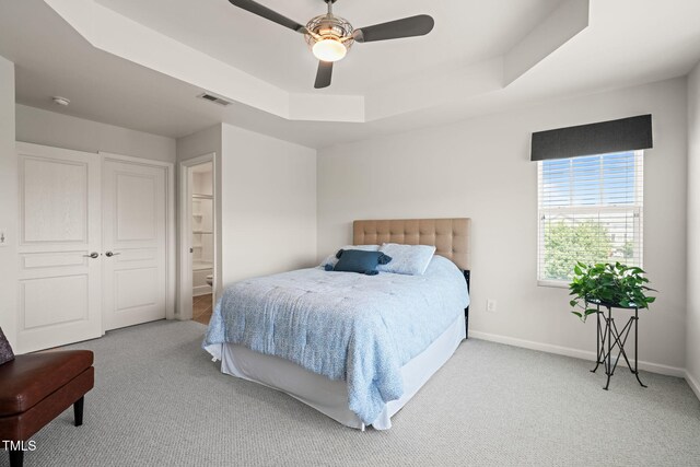 9141 Falkwood Rd, Raleigh, NC 27617 - carpeted bedroom featuring a raised ceiling, connected bathroom, and a ceiling fan