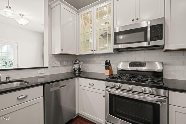 9141 Falkwood Rd, Raleigh, NC 27617 - kitchen with appliances with stainless steel finishes, white cabinets, and backsplash