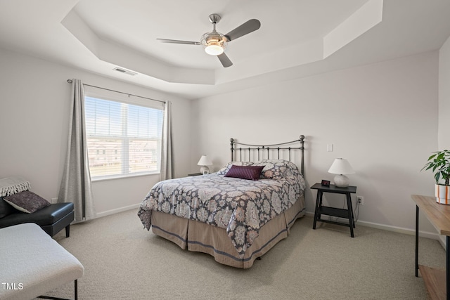 9141 Falkwood Rd, Raleigh, NC 27617 - carpeted bedroom featuring a tray ceiling and a ceiling fan
