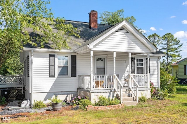 506 Currin St, Durham, NC 27703 - view of front of home with a porch, a chimney, roof with shingles, and a front lawn